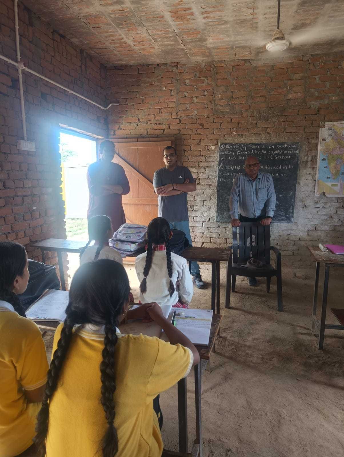 Trust representatives speaking with students in a village classroom